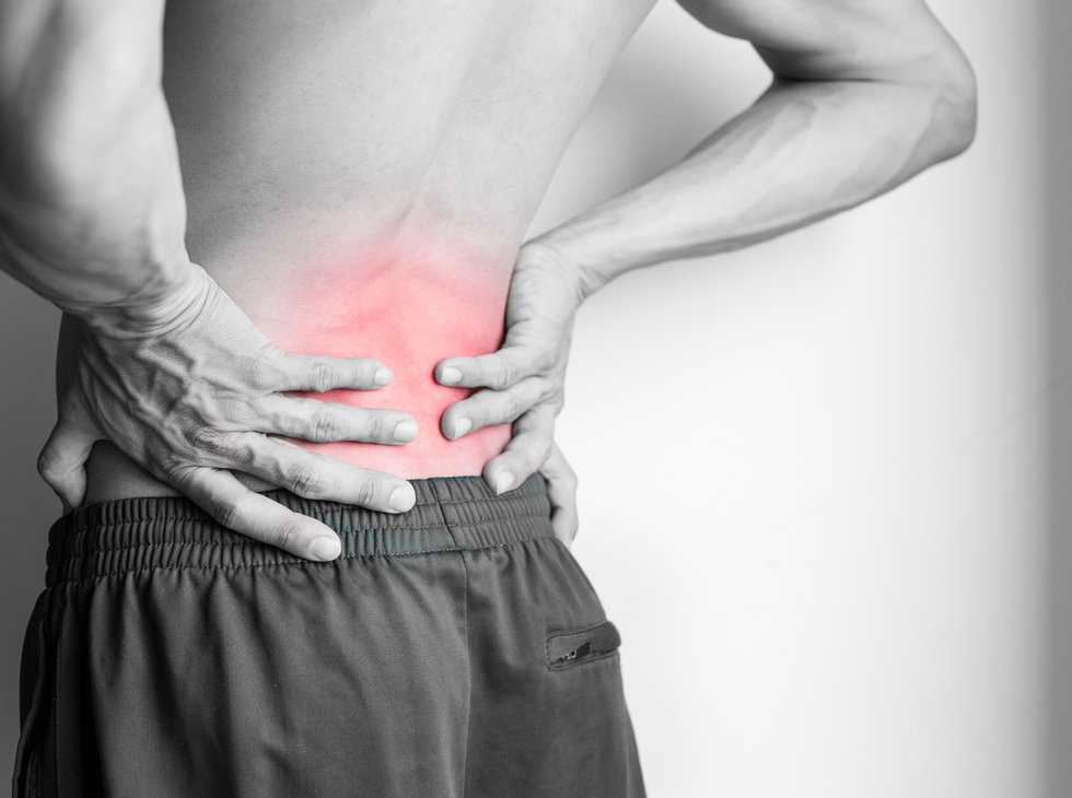 Athletic man&#x27;s back pain isolated in black and white